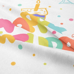 Close-up of woven fabric texture with Happy Birthday cartoon print and cake design