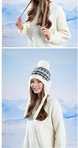 Détail d'un bonnet d'hiver en tricot blanc avec pompon doux et cache-oreilles épais