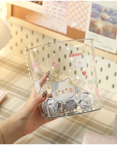 Close-up of a clear desktop trash bin with cute cartoon stickers and polished finish