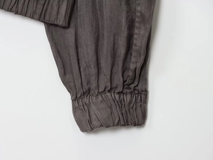 Close-up of elastic ribbed cuff on dark gray bomber jacket with fine woven texture