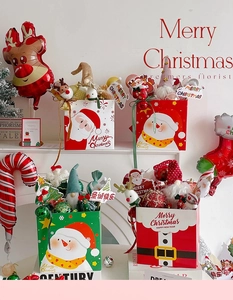Coffret cadeau de Noël avec gnomes en peluche et ornements festifs sur un manteau blanc