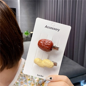 Detailed view of handmade creative hair clips shaped like realistic red dates and peanuts