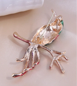 Close-up of the golden pin back and fastener on a magpie enamel bird brooch
