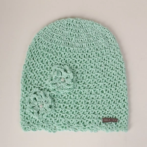 Detail of mint green crochet hat featuring 3D flowers with pearls and leather label