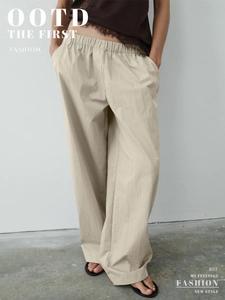 Detail of light beige wide-leg trousers with elastic waistband and natural cotton texture