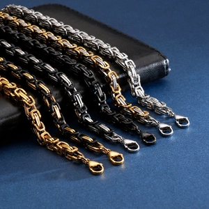 Detailed macro shot of Byzantine chains in gold, silver, and black with lobster clasps