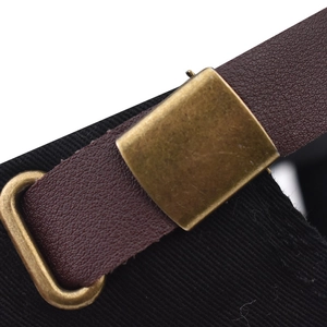 Detail of the brown leather back strap and antique bronze metal buckle on a black cap