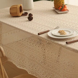 Detailed macro view of beige Christmas lace tablecloth with fine snowflake hollow patterns
