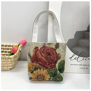 Detail of floral embroidery canvas tote with red rose pattern and beige top handles