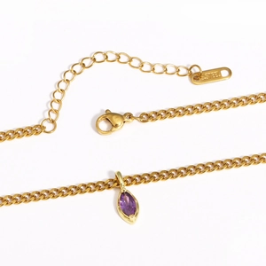 Detail of gold stainless steel necklace featuring a purple marquise cut gemstone pendant