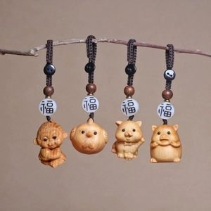 Macro shot of handcrafted wooden zodiac keychain charms featuring Monkey, Rooster, Dog and Pig
