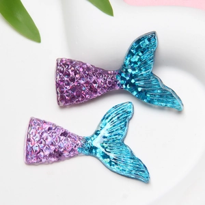 Macro shot of purple-blue gradient resin mermaid tails with glitter and scale textures