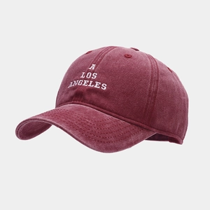 Macro detail of wine red washed cotton baseball cap with white A Los Angeles embroidery