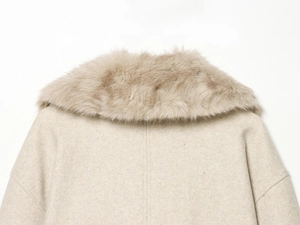 Detail of soft faux fur collar and premium beige fabric texture on women's winter coat