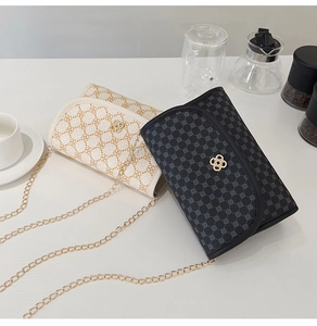 Close-up of dual-color crossbody bags with clover pattern and gold chain straps