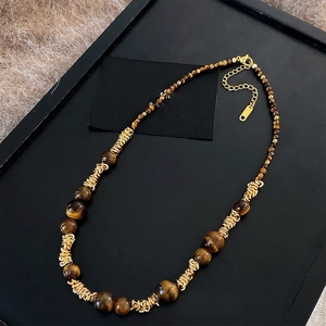 Dettaglio macro della collana occhio di tigre con spirali dorate e info lunghezza 39cm