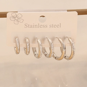 Macro shot of three pairs of silver stainless steel hoop earrings with sparkling rhinestones