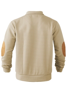 Detail view of beige quilted sweater back with brown faux suede elbow patches and ribbed cuffs