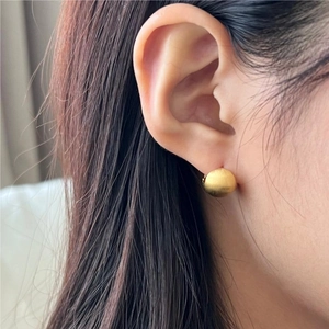 Minimalist 925 sterling silver ball earring with golden matte brushed finish on model