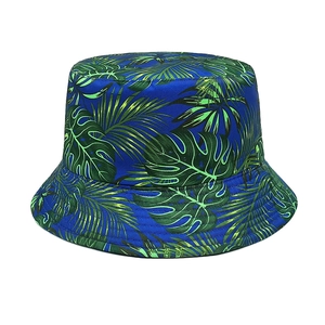Detailed view of the tropical green palm leaf print on a dark blue bucket hat
