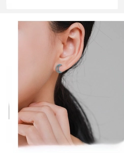 Macro detail of S925 silver crescent moon earrings with turquoise pave setting