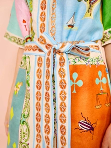 Detailaufnahme des bunten bedruckten Gürtels und der Leinenstruktur am Sommerkleid