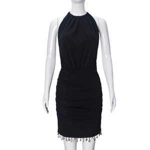 Detail of black halter dress featuring metallic round disk charms along the hemline