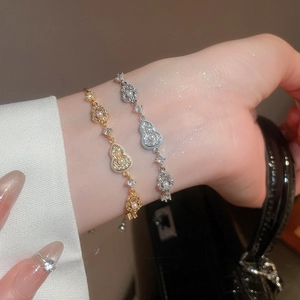 Close-up of elegant gold and silver gourd bracelets with pearls and zircons on wrist