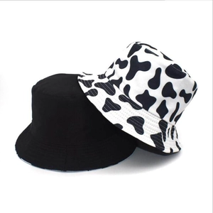 Close-up of double-sided bucket hat with black cow print and solid black fabric texture