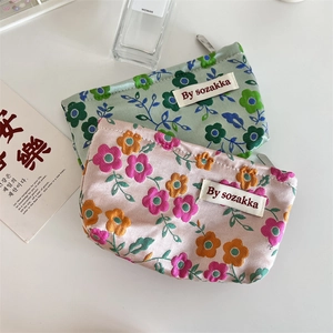 Detail of floral embossed cosmetic bag with silk texture and sturdy metal zipper closure