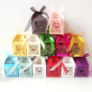 Laser-cut heart-shaped wedding favor boxes in various colors with ribbon ties
