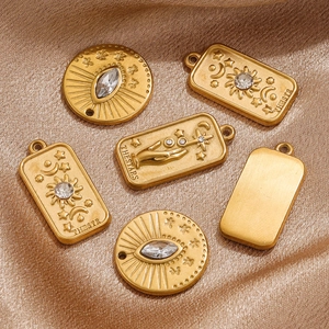 Macro shot of gold tarot pendants with embossed star and moon designs on silk