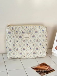 Detail of quilted bunny floral makeup bag with lace trim and vintage woven label