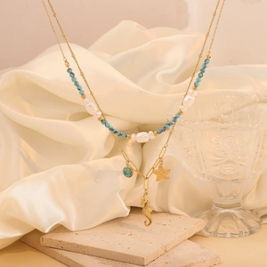 Gold double-layered necklace with turquoise beads, seahorse and starfish charms on silk