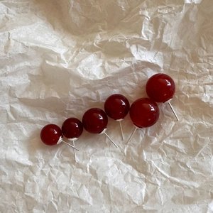 Detailed size comparison of red agate stud earrings from 4mm to 10mm on beige paper