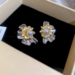 Detailed close-up of multilayer flower pearl earrings with gold and silver petals