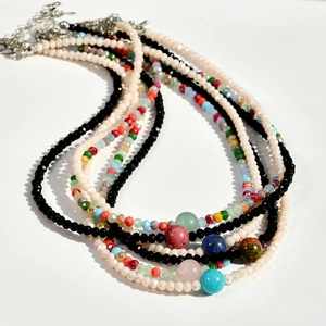 Detail of layered bohemian necklaces featuring natural stones and faceted beads