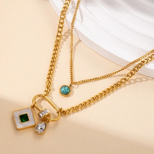 Dettaglio di collana a doppio strato in acciaio dorato con turchese e pendenti con strass