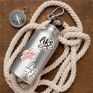 Close-up of holographic inspirational text stickers on a metal water bottle for travel