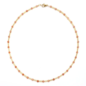 Detail of beaded sweater necklace with orange faceted stones and gold metal tubes