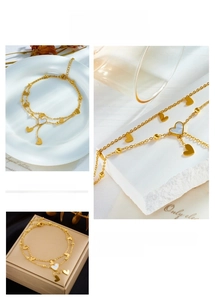 Detail view of double-layered gold heart anklet with mother of pearl pendant and chain