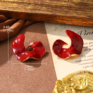 Detailed view of red enamel wave earrings with dimensions on vintage background