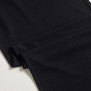 Gros plan détaillé montrant la texture du tricot noir de ce cardigan court élégant