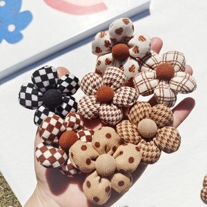 Detailed view of checkered and polka dot cotton flower patches on outdoor grass