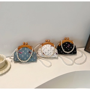 Detailed view of mini lace bags with pearl chains in blue, white, and black colors