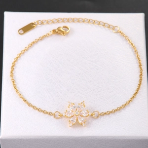 Dettaglio del bracciale a fiori dorato con zirconi e chiusura a moschettone regolabile