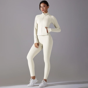 Detail view of cream long sleeve zip-up yoga jacket with thumbholes and high waist leggings