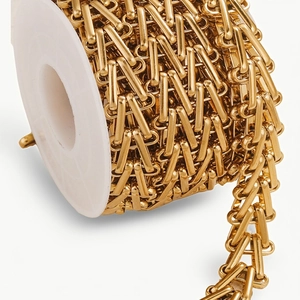 Macro shot of polished gold-finished geometric stainless steel DIY link chain on a spool