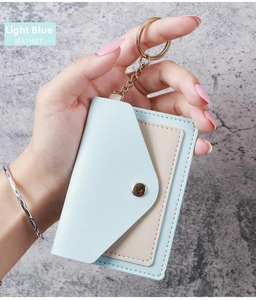 Detail of light blue faux leather card holder with gold keychain and button closure