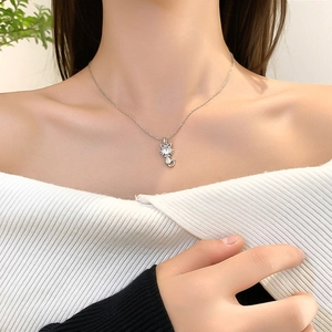 Minimalist silver kitten pendant necklace with zircon stone on model collarbone